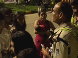 खजराना चौराहे पर पुलिस अधिकारी से बहस करतीं गर्भवती महिला और उनके परिजन; महिला की गोद में नवजात बच्चा स्पष्ट रूप से दिख रहा है।