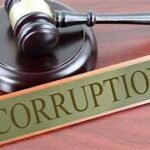 न्याय की हथौड़ी और भ्रष्टाचार का बोर्ड एक मेज पर रखा हुआ — शिक्षा विभाग में भ्रष्टाचार का प्रतीक