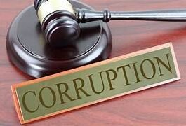 न्याय की हथौड़ी और भ्रष्टाचार का बोर्ड एक मेज पर रखा हुआ — शिक्षा विभाग में भ्रष्टाचार का प्रतीक