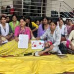 भोपाल में धरना दे रही ANM महिला कार्यकर्ता, एक महिला लेटी हुई है और हाथ में खून से लिखा पत्र पकड़े हुए हैं।